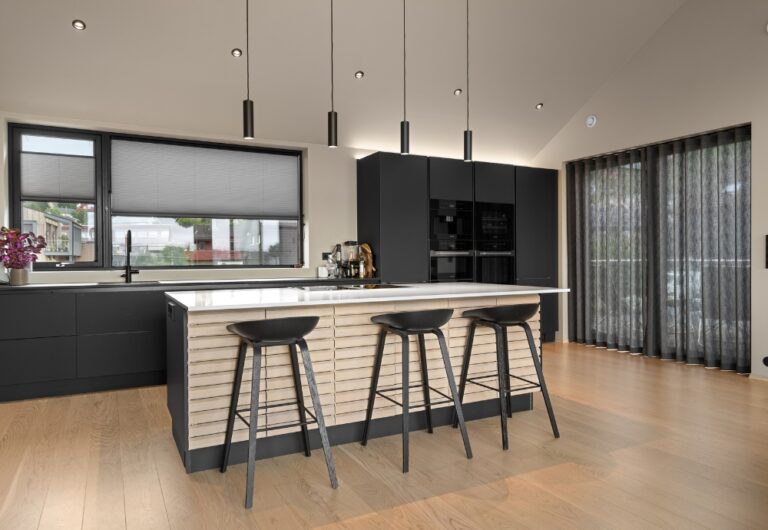 Innvendig solskjerming i form av plisségardiner og gardin på et kjøkken.